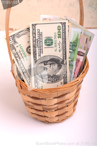 Image of money set in a basket, dollars, euro
