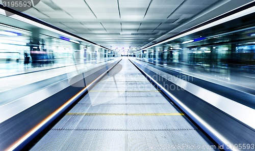 Image of symmetric moving blue escalator inside contemporary airport