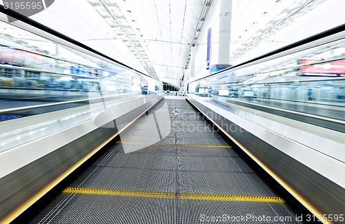 Image of symmetric moving blue escalator inside contemporary airport