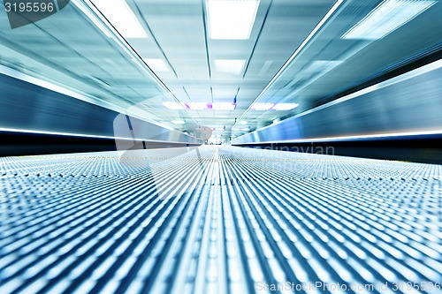 Image of symmetric moving blue escalator inside contemporary airport