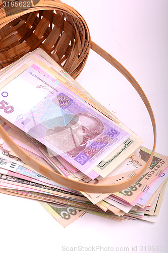 Image of money set in a basket, dollars, euro and ukrainian money