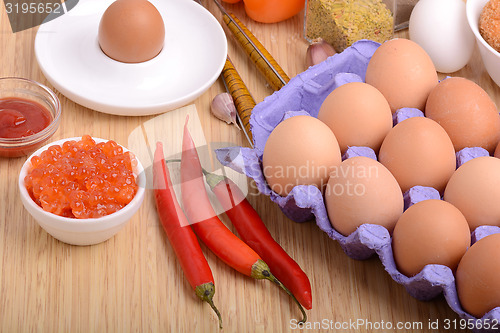 Image of eggs on eggshell and red pepper, red caviar and tomato