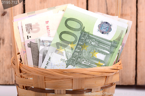 Image of money set in a basket, dollars, euro and russian money