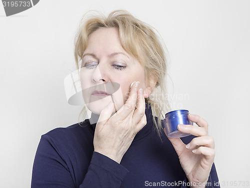 Image of elderly woman with face cream