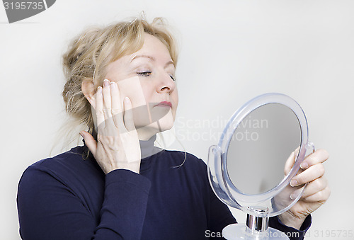 Image of older woman looking in mirror