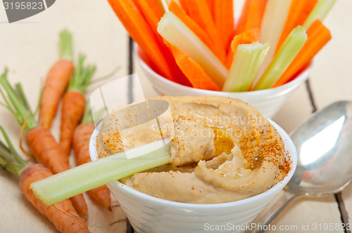 Image of fresh hummus dip with raw carrot and celery 