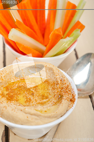 Image of fresh hummus dip with raw carrot and celery 