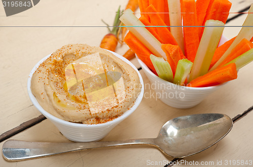 Image of fresh hummus dip with raw carrot and celery 