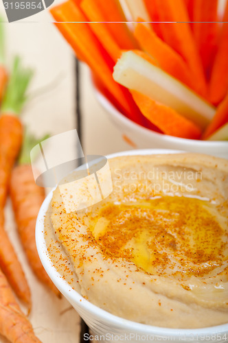 Image of fresh hummus dip with raw carrot and celery 