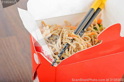 Image of Meat and noodles in red take away container