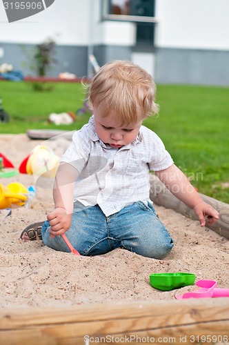 Image of Child playing on playground in sandbox