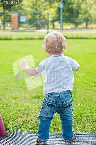 Image of Baby kid walking on the green grass