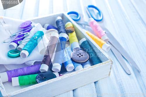 Image of Scissors, bobbins with thread and needles