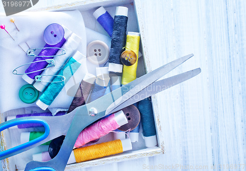 Image of Scissors, bobbins with thread and needles