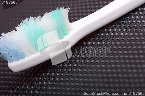 Image of close - up old toothbrush on black material