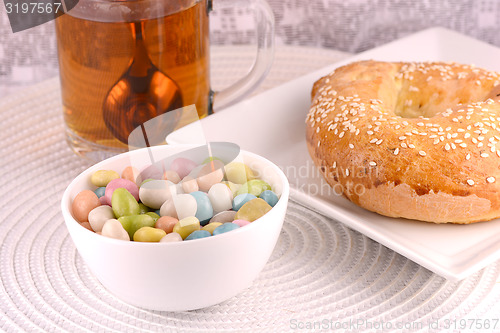 Image of A cup of tea with a cake and candies