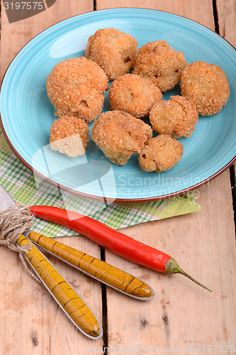 Image of meat chop on blue plate with red pepper