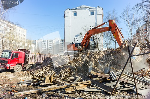 Image of Excavator loads garbage from demolished house