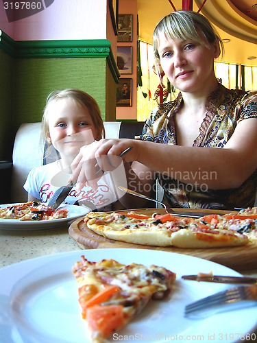 Image of Happy mother and her child in pizzeria