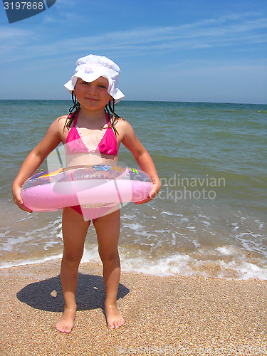 Image of little girl with inflatable circle at the sea