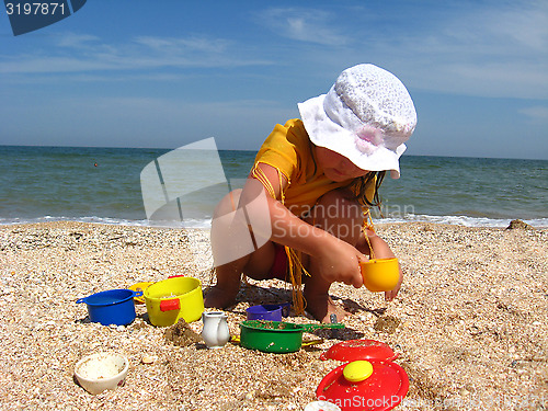 Image of little girl plays at the sea