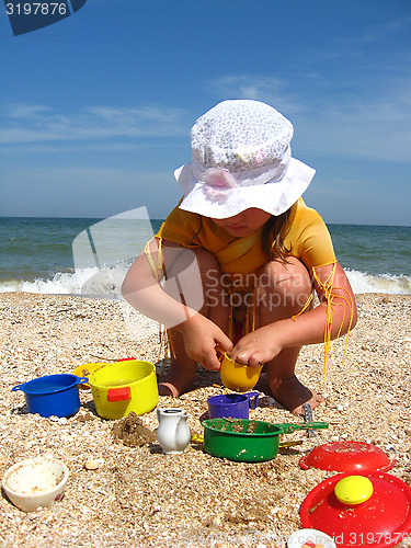 Image of little girl plays at the sea