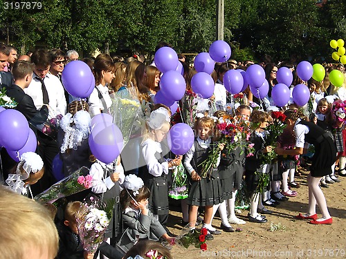 Image of children with flowers and balloons on a holiday of the 1st september