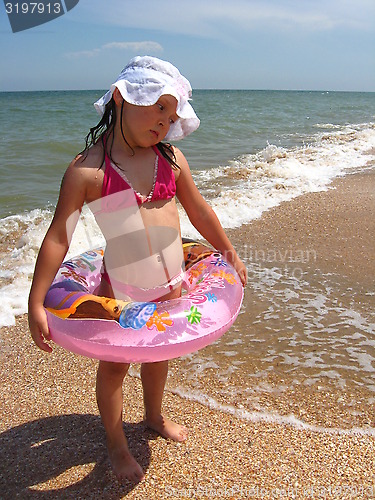 Image of little girl plays at the sea