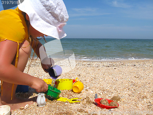 Image of little girl plays at the sea