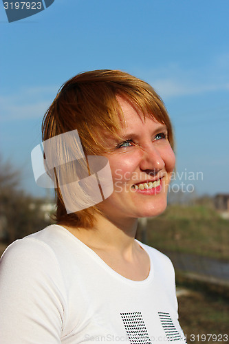 Image of blue-eyed sympathetic girl looking at the sky