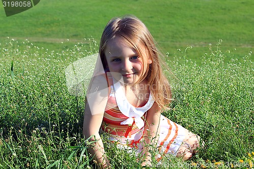 Image of portrait of little girl lying on the grass