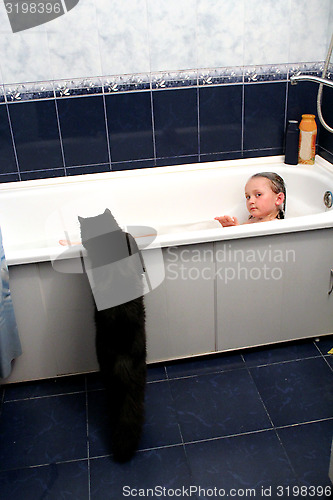 Image of little girl taking a bath with curious black cat