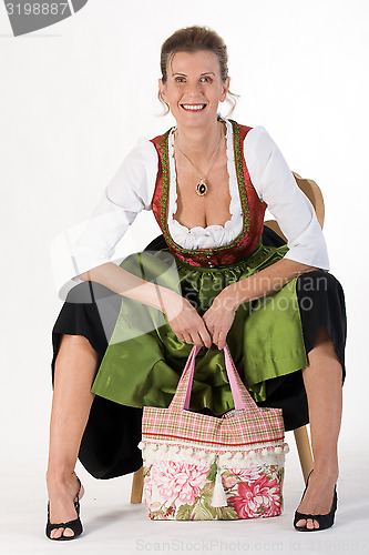 Image of elderly woman in Bavarian costume dress with bag