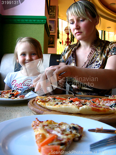 Image of mother and daughter eating in pizzeria