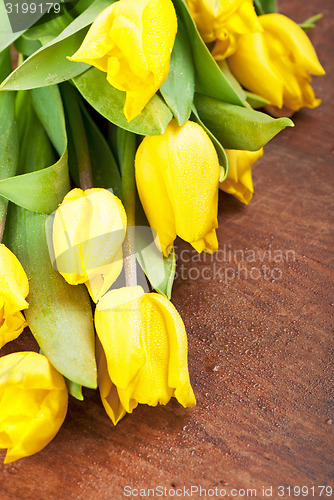 Image of Yellow tulips on a wooden 