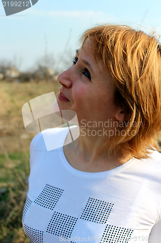 Image of blue-eyed sympathetic girl looking at the sky