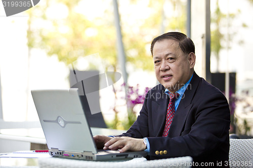 Image of Asian businessman using laptop