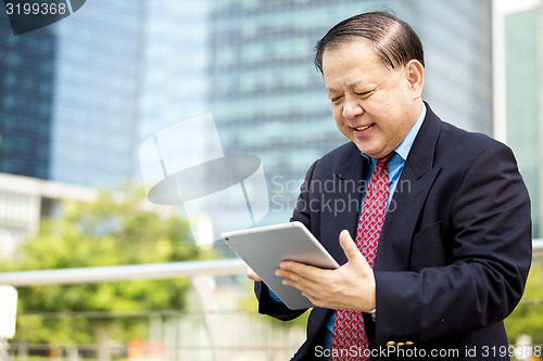 Image of Asian businessman using tablet
