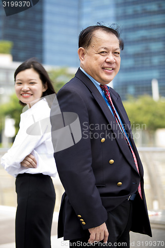 Image of Asian businessman and young female executive smiling portrait