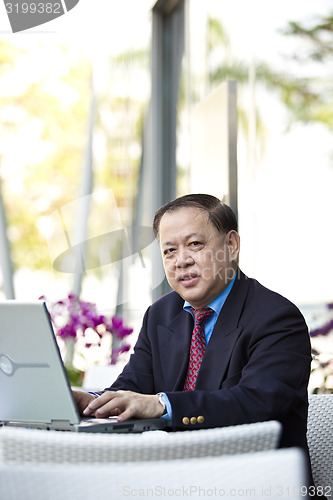 Image of Asian businessman using laptop