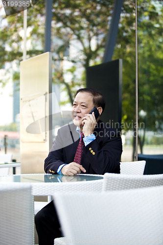 Image of Asian businessman talking on smart phone