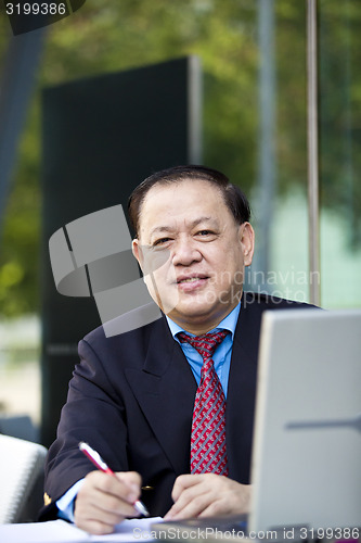 Image of Asian businessman writing proposal