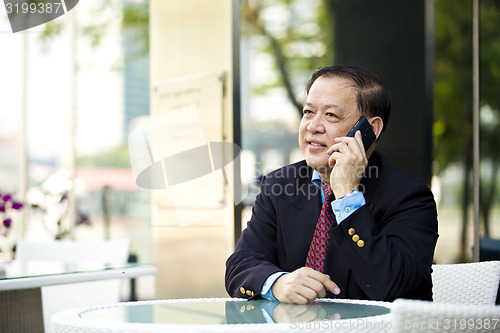 Image of Asian businessman talking on smart phone