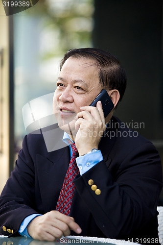 Image of Asian businessman talking on smart phone