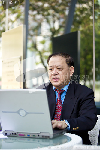 Image of Asian businessman using laptop