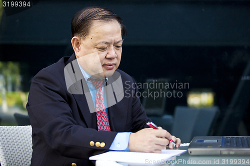 Image of Asian businessman writing proposal