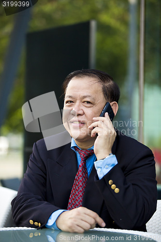 Image of Asian businessman talking on smart phone