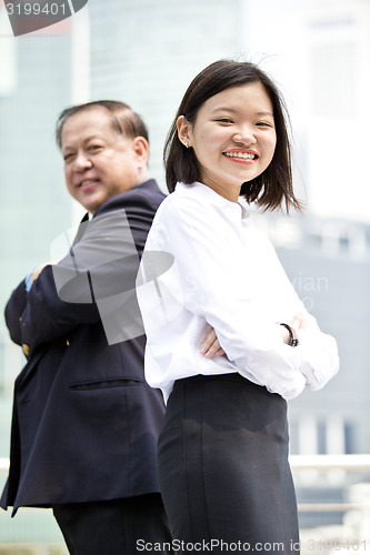 Image of Asian businessman and young female executive smiling portrait