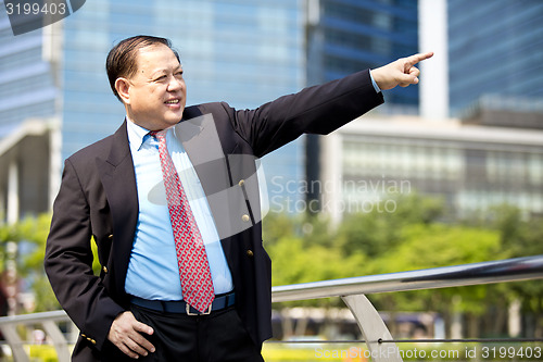 Image of Asian businessman pointing at a direction