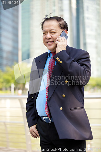 Image of Asian businessman talking on smart phone